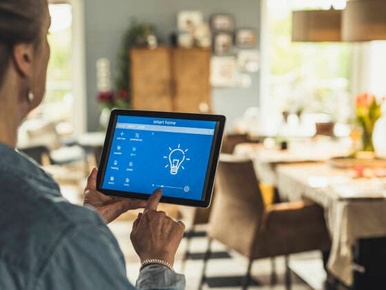 Woman operating home automation device through digital tablet at home model released Symbolfoto property released UUF23705