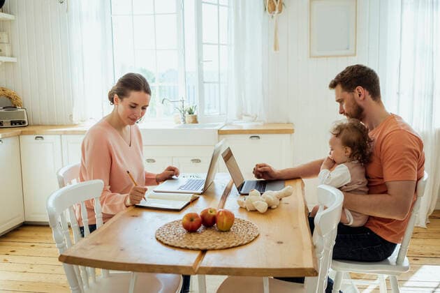 Male and female professionals working at dining table in kitchen model released Symbolfoto property released VPIF04339