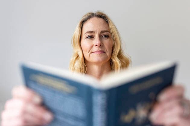 Mature woman reading book at home model released Symbolfoto property released WPEF04983