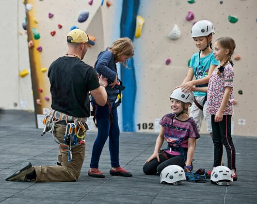 IMAGO Creative: Lokalhelden - Jugendsportbildung climbing coach helps girl putting climbing harness London, England, United Kingdom CR_THHE210715-797608-01 ,model released, Symbolfoto ,property released