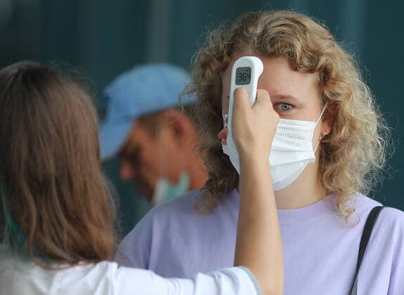 IVANOVO, RUSSIA - JULY 27, 2021: A woman has her body temperature measured ahead of receiving a COVID-19 vaccine at a mobile vaccination center at a railway station. Vladimir Smirnov TASS  TS109CF2