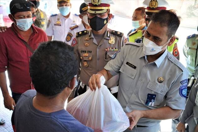 Indonesia: Sharing Aid during pandemic A number of personnel from the Traffic Directorate of the South Sulawesi Police provided food and mask assistance to drivers and passengers at the Mallengkeri Terminal, Makassar City, Indonesia, during the implementation of level IV Community Activity Restrictions (PPKM). In addition, free health checks were carried out for drivers to detect Covid-19. Makassar South Sulawesi Indonesia Copyright: HerwinxBahar