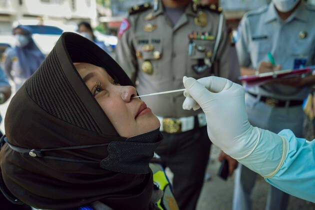 July 28, 2021, Makassar, South Sulawesi, Indonesia: A female police officer is undergoing an antigen swab test while at the Mallengkeri City transportation terminal, Makassar, Indonesia. This swab examination was carried out to detect the spread of Covid-19 in Indonesia. Makassar Indonesia - ZUMAb223 20210728_zip_b223_005 Copyright: xHerwinxBaharx