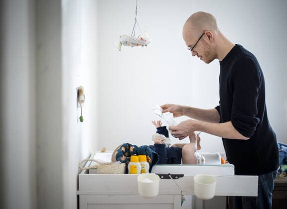 IMAGO Creative: Vaterschaft Symbolfoto: Ein Vater Mann wechselt einem Baby die Windel auf dem Wickeltisch. Berlin, 02.02.2021. Berlin Deutschland *** Symbol photo A father man changes a babys diaper on the changing table Berlin, 02 02 2021 Berlin Germany Copyright: xJaninexSchmitz photothek.dex