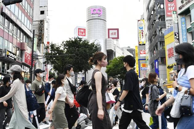 Surge in COVID-19 cases in Japan People wearing face masks walk across a scramble intersection in Tokyo s Shibuya area on July 30, 2021. The Tokyo metropolitan government confirmed 3,300 daily coronavirus cases the same day as the capital, where the Olympics are being held, is experiencing a surge in infections.  A14AA0000755318P
