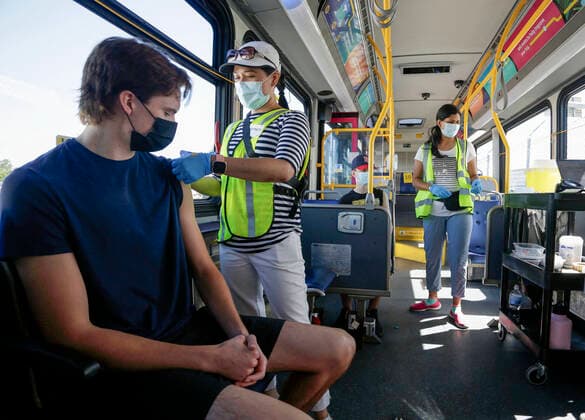 (210730) -- DELTA (CANADA), July 30, 2021 -- A man receives the COVID-19 vaccine on a COVID-19 vaccine bus at Tsawwassen Ferry Terminal in Delta, British Columbia, Canada, on July 30, 2021. The vaccine bus is part of Vax for B.C. campaign in British Columbia aimed at boosting up the vaccination rate. (Photo by Xinhua) CANADA-DELTA-COVID-19-VACCINE BUS LiangxSen 