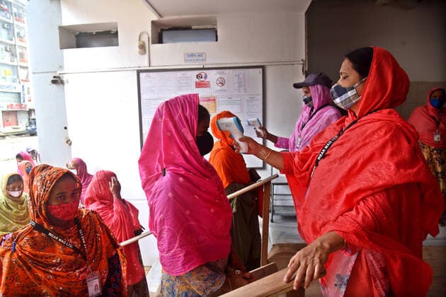 Virus Outbreak Bangladesh Security personal checks the body temperature of Garment workers before entering a Garment factory after garment factories reopened during Covid-19 lockdown in Dhaka, Bangladesh, on August 1, 2021. Dhaka Bangladesh rashid-garments210801_np0XL  Copyright: xSTRx