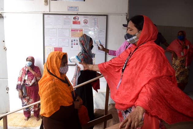 Virus Outbreak Bangladesh Security personal checks the body temperature of Garment workers before entering a Garment factory after garment factories reopened during Covid-19 lockdown in Dhaka, Bangladesh, on August 1, 2021. Dhaka Bangladesh rashid-garments210801_npX9s  Copyright: xSTRx