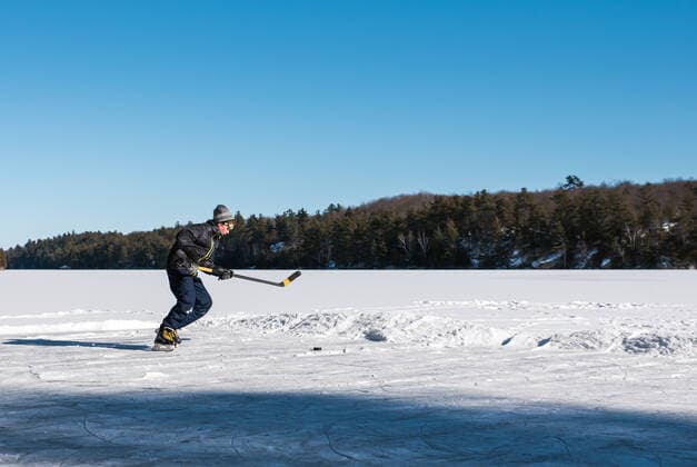 IMAGO Creative, Winter, Winterspaß, Eishockey #2 Teen boy playing hockey on an outdoor rink on a frozen lake in Canada. Kingston, ON, Canada CR_DOHO210212G-644448-01 ,model released, Symbolfoto