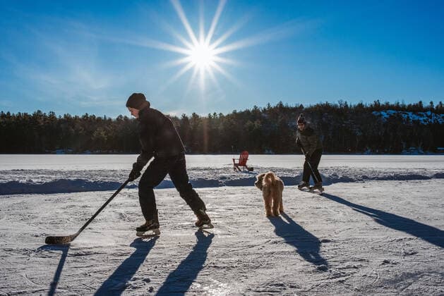 IMAGO Creative, Winter, Winterspaß, Eishockey #2 Father and son playing hockey on outdoor rink on frozen Canadian lake. Kingston, ON, Canada CR_DOHO210212G-644452-01 ,model released, Symbolfoto