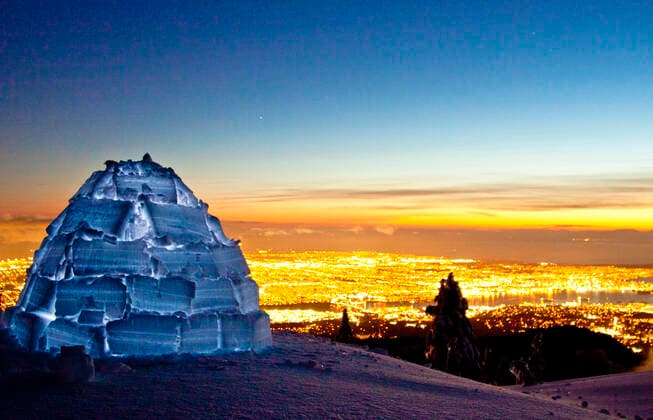 Igloo on mountain summit above city lights of Vancouver, Canada. Vancouver, BC, Canada CR_JDIP210506-715525-01