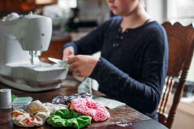 IMAGO Nature: Unsere Erde, Umweltverträgliche Herausforderungen, Recycling Girl sitting at kitchen table making hair ties on sewing machine Hillsdale, MI, United States CR_OMHX210216B-638951-01 ,model released, Symbolfoto