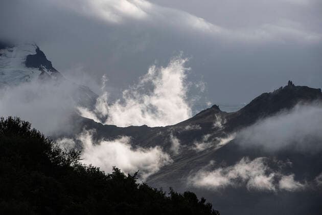 Creative Highlights World clouds forming around a mountain ridge at Skaftafell Nation Park Skaftafell, Iceland CR_THHE210205A-632862-01