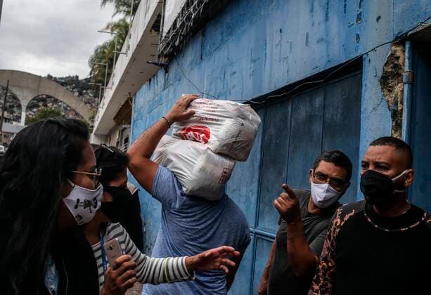 Volunteers from the Adopt a Family project distribute food baskets to residents of the Rocinha favela today, in Rio de Janeiro, Brazil, 03 August 2021. The project serves more than 2,000 families in need affected by the covid-19 pandemic along with local NGOs and donations of hygiene kits, masks and alcohol gel. Solidarity network serves families affected by the pandemic in Rio de Janeiro !ACHTUNG: NUR REDAKTIONELLE NUTZUNG!  Copyright: xAndrexCoelhox AME6681 20210803-d133624f23ca5907bebbca45e5161903d9307596