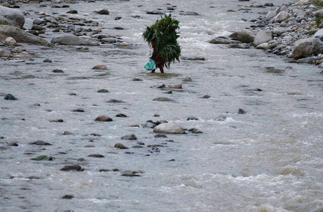 IMAGO Nature: Unsere Erde, Klimawandel, Überschwemmungen News Bilder des Tages August 4, 2021, Kathmandu, Nepal: A woman carrying grass on her back for cattle crosses a river in Sindhupalchok district, Nepal on Wednesday, August 4, 2021. Kathmandu Nepal - ZUMAg200 20210804_zap_g200_010 Copyright: xSkandaxGautamx