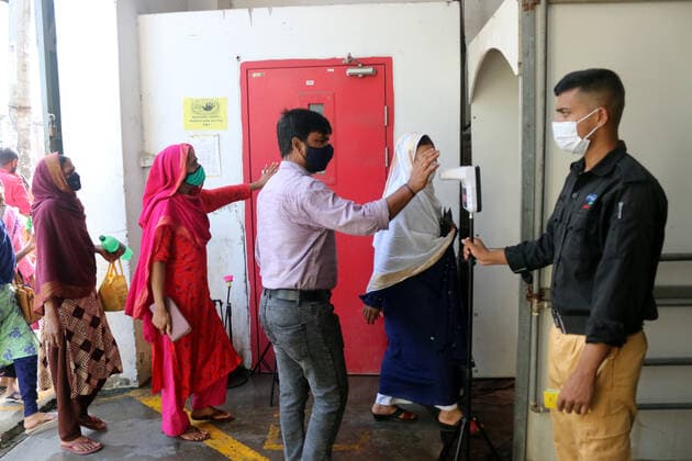 August 5, 2021 , Dhaka, Bangladesh: Security personal checks the body temperature of Garment workers before entering a Garment factory after garment factories reopened during Covid-19 lockdown in Dhaka. Dhaka Bangladesh - ZUMAr336 20210805_int_r336_015 Copyright: xHabiburxRahmanx