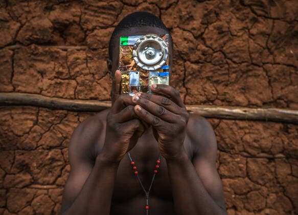 July 21, 2021, Nairobi, Kenya: NAIROBI,KENYA-JULY 21, 2021: 18-year-old Saviour Omondi takes a posture by his neighborhood in Kibera holding a pieces of art that he makes using recycled beer cans and pieces of iron sheets. Saviour Omondi, an 18-year-old artist born and raised in Kibera, Nairobi Kenya. From a family of five, he began his love for art back in 2009 by copying and learning most skills from his dad who was doing art but not to a professional level. OmondiÃ¢â‚¬â ¢s main focus was to portray his home through his artwork and dreamt of making the best out of his art in the future after his studies. Despite his dad being a drunkard and all the late-night fights he brought home, Saviour recycled most of his dad s beer cans and made cr - ZUMAd156 20210721_zip_d156_003 Copyright: xDonwilsonxOdhiambox