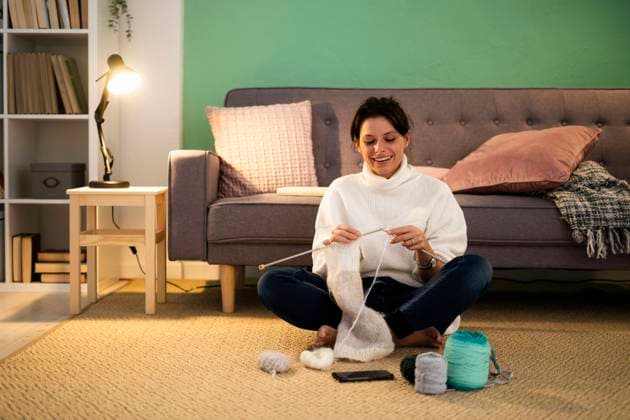 Happy mid adult woman knitting wool at home model released Symbolfoto property released GIOF09303