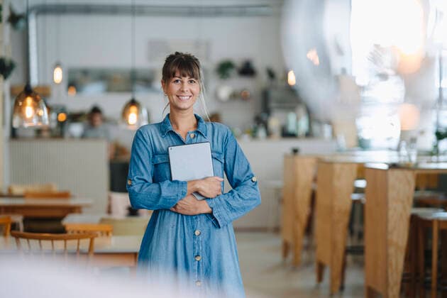 IMAGO Creative: Kreative Renaissance -- der junge Entrepreneur Happy female entrepreneur using digital tablet while standing in coffee shop model released Symbolfoto property released GUSF04624