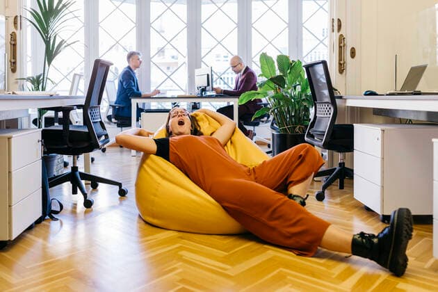IMAGO Creative: Internationaler Frauentag, Mental Load und Care-Arbeit Exhausted businesswoman resting on bean bag in office model released Symbolfoto property released JRFF04867