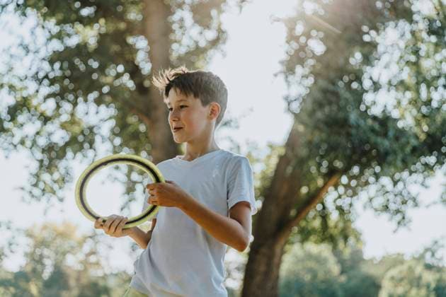 Boy throwing frisbee ring while standing in public park model released Symbolfoto MFF06407