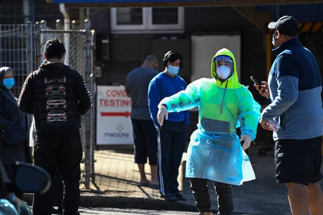 NSW CORONAVIRUS COVID19, A health worker dressed in Personal Protection Equipment (PPE) directs people as they line up for their COVID-19 test at the Yagoona MedLab Pathology Walk-in clinic in Sydney, Saturday, August 7, 2021. Greater Sydney and surrounding regions are in lockdown until at least August 28 and the NSW Hunter will be locked down for a week as health authorities battle to contain an outbreak of the virulent Delta strain. ( NO ARCHIVING, EDITORIAL USE ONLY, NO USE IN BOOKS WITHOUT CONSENT SYDNEY NSW AUSTRALIA  Copyright: xBIANCAxDExMARCHIx 20210807001565067388