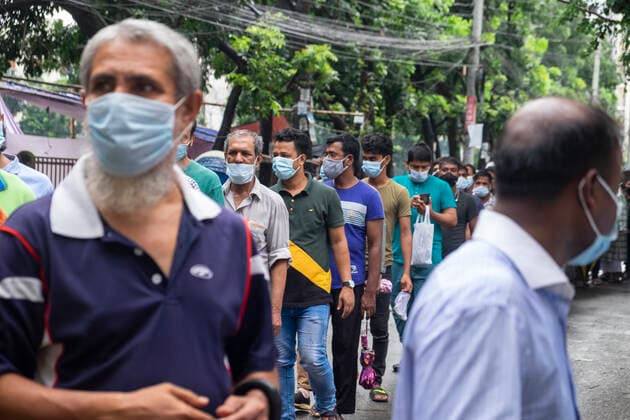 Bangladesh begins nationwide Covid-19 vaccination drive People wait in line in front of Lalmatia Housing Society School & College which has been converted into a vaccination center. Dhaka Bangladesh Lalmatia Copyright: RizwanxHasan