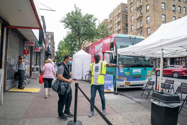 Mobile vaccination pop-up site in the Bronx Mobile vaccination pop-up site set up in the Bronx for COVID-19 vaccine available to passerby people at no cost with prepaid VISA $100 card as insensitive. City administration set up one hundred dollar insensitivity to get more people to get vaccinated amid surge of Delta variant and rise in the number of infections. The site is set by NNYC Health and Hospitals system and will remain for 3 days. They will retrun back for second dose jab on the same location in three weeks. Health worker directs patient to get vaccine. New York New York United States Corner of West 231st street and Copyright: LevxRadin