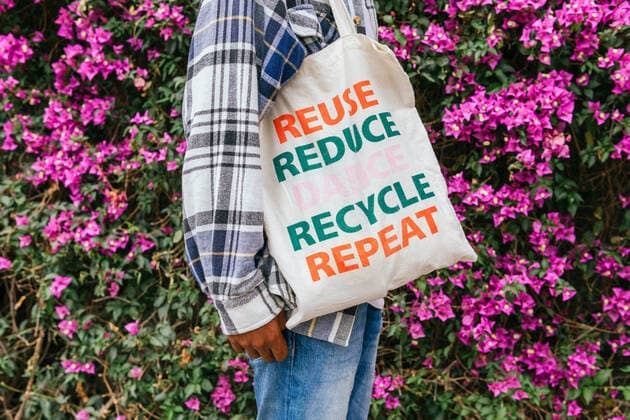 IMAGO Nature: Unsere Erde, Umweltvertr?gliche Herausforderungen, Recycling Side view of cropped unrecognizable African American male standing with eco friendly shopping bag in blooming summer garden DavidMunoz_IssaBcn_39.jpg Copyright: xDavidxMunozx Model Released