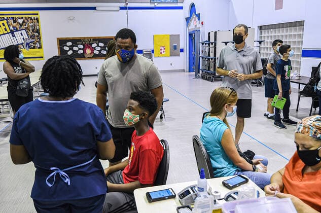 August 9, 2021, Longwood, Florida, United States: People wait to receive a dose of COVID-19 vaccine at a vaccination clinic at Lyman High School in Longwood on the day before classes begin for the 2021-22 school year. Seminole County Public Schools have implemented a face covering mask mandate for students for 30 days unless a parent chooses to opt out of the requirement. Longwood United States - ZUMAs197 20210809_zaa_s197_199 Copyright: xPaulxHennessyx