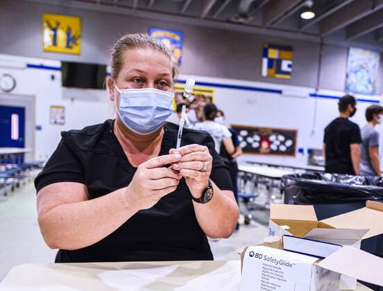 August 9, 2021, Longwood, Florida, United States: Jackie Ready prepares a dose of the Pfizer vaccine at a COVID-19 vaccine clinic at Lyman High School in Longwood on the day before classes begin for the 2021-22 school year. .Seminole County Public Schools have implemented a face covering mask mandate for students for 30 days unless a parent chooses to opt out of the requirement. Longwood United States - ZUMAs197 20210809_zaa_s197_200 Copyright: xPaulxHennessyx