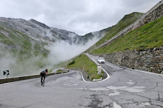 Rennradfahrer auf dem Gebirgspass Stilfser Joch, Passo dello Stelvio. Der Passo dello Stelvio verbindet Prad im Vinschgau Südtirol mit Bormio im Veltlin Lombardei. *** Road cyclist on the mountain pass Stilfser Joch, Passo dello Stelvio The Passo dello Stelvio connects Prad in Vinschgau South Tyrol with Bormio in Veltlin Lombardy
