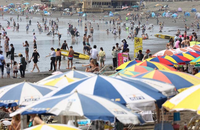August 11, 2021, Fujisawa, Japan - Katase Enoshima beach is crowded with bathers and beach umbrellas amid outbreak of the new coronavirus in Fujisawa, suburban Tokyo on Wednesday, August 11, 2021.  (166936596)