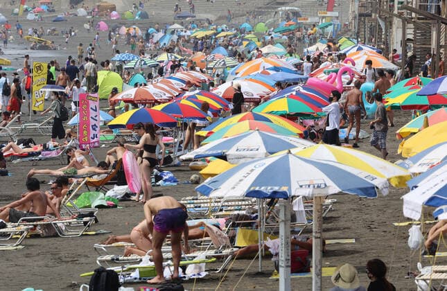 August 11, 2021, Fujisawa, Japan - Katase Enoshima beach is crowded with bathers and beach umbrellas amid outbreak of the new coronavirus in Fujisawa, suburban Tokyo on Wednesday, August 11, 2021.  (166936598)