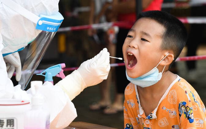 (210811) -- HAIKOU, Aug. 11, 2021 -- A medical worker takes a swab sample from a child at a COVID-19 nucleic acid testing site in Yunlong Township of Haikou, south China s Hainan Province, Aug. 11, 2021. Yunlong launched its thrid round of mass nucleic acid testing on Wednesday. ) CHINA-HAIKOU-YUNLONG-COVID-19-TESTING (CN) YangxGuanyu 