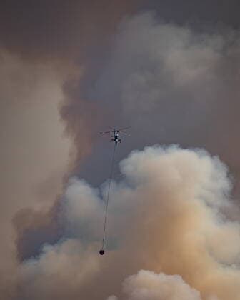 August 11, 2021, MERRITT, BC, Canada: A helicopter with a water bucket flies past smoke rising into the air while battling the July Mountain wildfire along the Coquihalla Highway south of Merritt, B.C., on Wednesday, August 11, 2021. MERRITT Canada  - ZUMAc35_ 20210811_zaf_c35_268 Copyright: xDarrylxDyckx