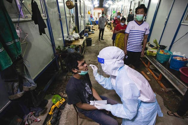 August 12, 2021, Bangkok, Thailand: Zendai volunteer staff wearing a Personal Protective Equipment ( PPE) suit takes a nasal swab from a worker at construction workers camp in Laksi..Covid-19 check-up in construction workers camp in Bangkok. Bangkok Thailand - ZUMAs197 20210812_zaa_s197_057 Copyright: xVaruthxPongsapipattx