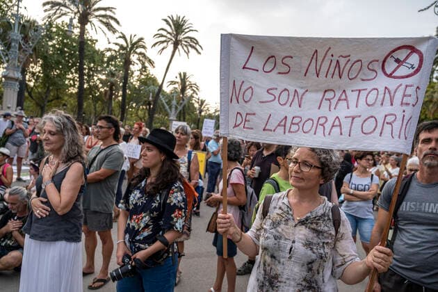 August 14, 2021, Barcelona, Spain: A protester holding a banner against childhood Covid 19 vaccination, during the demonstration..Hundreds of people have gathered at the Arc de Triomphe against the campaign launched by the Department of Health and the Spanish Government to vaccinate children against Covid 19. Barcelona Spain - ZUMAs197 20210814_zaa_s197_200 Copyright: xPacoxFreirex