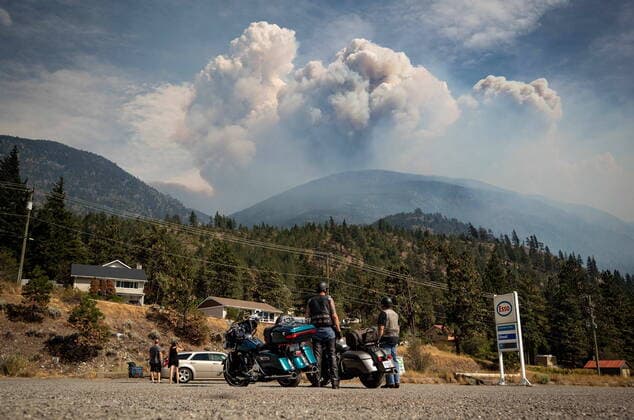 Bilder des Jahres 2021, News 08 August News Themen der Woche KW32 News Bilder des Tages August 15, 2021, LYTTON, BC, CANADA: Motorcyclists stopped at a gas station watch as a pyrocumulus cloud, also known as a fire cloud, produced by the Lytton Creek wildfire rises into the sky from the fire burning in the mountains above Lytton, B.C., on Sunday, August 15, 2021. LYTTON CANADA  - ZUMAc35_ 20210815_zaf_c35_111 Copyright: xDarrylxDyckx