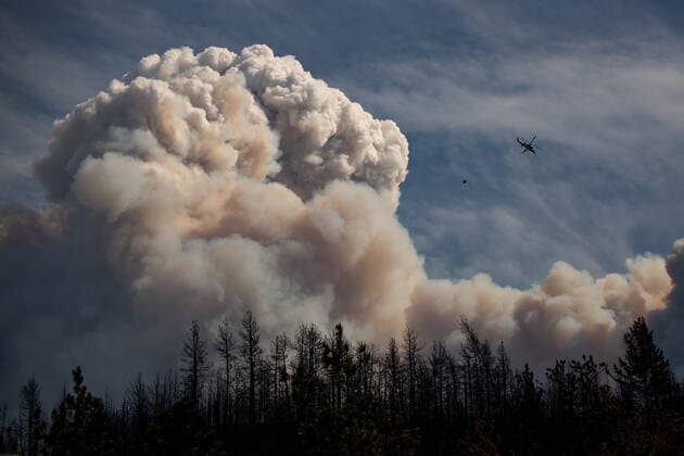 August 15, 2021, LYTTON, BC, CANADA: A helicopter carrying a water bucket flies past a pyrocumulus cloud, also known as a fire cloud, produced by the Lytton Creek wildfire burning in the mountains above Lytton, B.C., on Sunday, August 15, 2021. LYTTON CANADA - ZUMAc35_ 20210815_zaf_c35_134 Copyright: xDarrylxDyckx