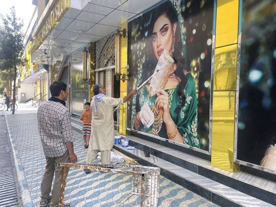 Frauen unter dem Taliban Regime in Afghanistan Bilder des Jahres 2021, News 08 August News Themen der Woche KW32 News Bilder des Tages Taliban insurgents enter Kabul A worker at a beauty salon paints over a large photo of a woman on the wall in Kabul on Aug. 15, 2021, following news that the Taliban swept into the Afghan capital.  A14AA0000757911P