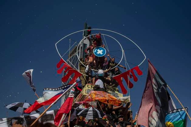 Persons hold a big eye, in support of the victims of eye trauma at the hands of the police (more than 400 victims who lost one or both eyes). Amid of the commemoration and demonstration in Plaza Dignidad (former Plaza Italia), one year after the beginning of the social outbreak of 18 October 2019 in Chile. What began as a student protest against the increase in the price of the underground ticket, ended up triggering a social, political and economic crisis that led to an upcoming plebiscite on 25 October 2020. To approve or reject a new political constitution. A year of continuous protests against the government of Sebasti‡n Pi–era, social inequality and the neoliberal system. October 18, 2020. Santiago, Chile. Santiago Chile Copyright: xClaudioxAbarcaxSandovalx