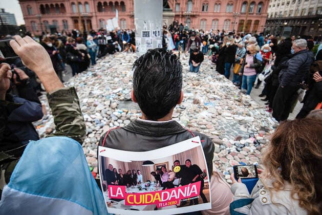 Coronavirus in Argentinien, Demonstration in Buenos Aires August 16, 2021, Buenos Aires, Argentina: A man with a poster that refers to the controversial photograph of President Alberto Fernandez during the strict restrictions due to Covid-19..March of the stones, a tribute to the victims of Covid-19 and repudiation of the government. The call seeks to represent with a rock each one of the deceased by coronavirus and expose it in front of the central government buildings, in repudiation of the management of the pandemic in Buenos Aires, Argentina. Buenos Aires Argentina - ZUMAs197 20210816_zaa_s197_134 Copyright: xManuelxCortinax