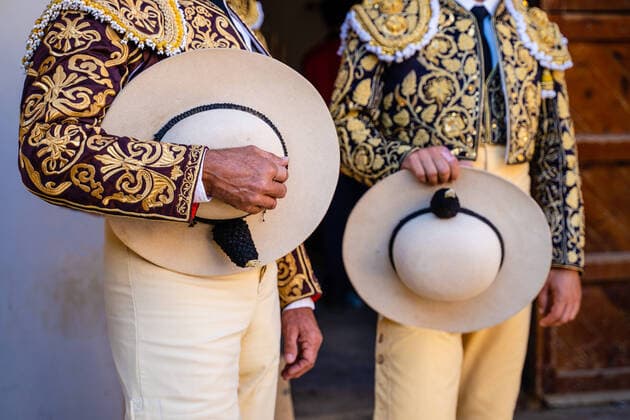 Creative Highlights Symbolbilder Crop unrecognizable bullfighters in traditional costume decorated with embroidery holding hats and preparing for corrida festival JavierDeLaTorre_Bullfight_36.jpg Copyright: xJavierxDexLaxTorrex Model Released