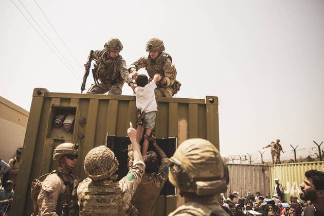 Bilder des Jahres 2021, News 08 August News Themen der Woche KW33 News Bilder des Tages Afghanistan, Evakuierungen am Flughafen in Kabul UK coalition forces, Turkish coalition forces, and U.S. Marines assist a child during an evacuation at Hamid Karzai International Airport, in Kabul, Afghanistan, August 20, 2021. U.S. service members are assisting the Department of State with a non-combatant evacuation operation (NEO) in Afghanistan.  WAX2021082002 STAFFxSGT.xVICTORxMANCILLA