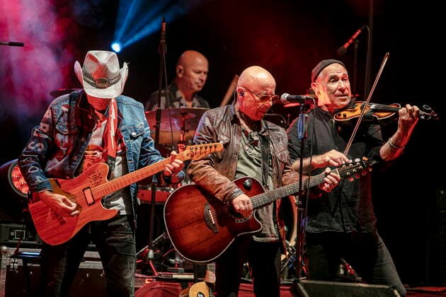Fritz Puppel (Gitarre), Roger Heinrich (Schlagzeug), Toni Krahl (Gesang, Gitarre) und Georgi Gogow (Geige) (L-R) von der 1972 in Ost-Berlin DDR gegründeten Gruppe CITY während des Candelight Open Air Rockkonzertes live in Coswig.