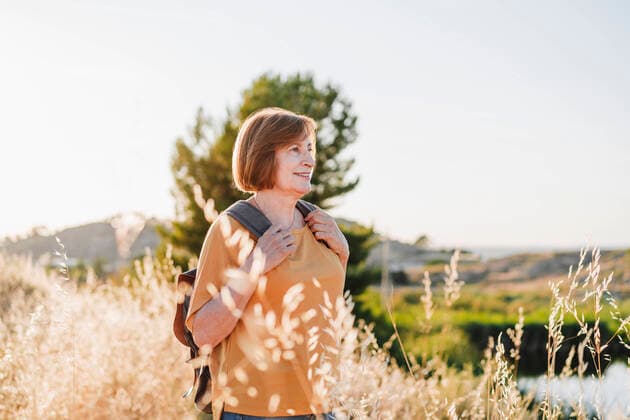 IMAGO Creative: Internationaler Frauenmonat, Gesundheit, Frauen in der Menopause Senior woman with short hair hiking during sunny day model released Symbolfoto EBBF04423