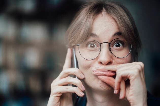 Female freelancer making face while talking on mobile phone in cafe model released Symbolfoto property released JOSEF05264