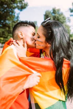 Young lesbian couple kissing in park model released Symbolfoto MEUF03638