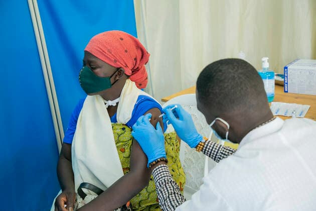 (210823) -- KIGALI, Aug. 23, 2021 -- A woman receives the COVID-19 vaccine at a vaccination site in Kigali, Rwanda, on Aug. 23, 2021. Rwanda on Monday started the third phase of mass COVID-19 vaccinations targeting adults 18 years and above in Kigali, the Ministry of Health said. (Photo by Xinhua) RWANDA-KIGALI-COVID-19-VACCINATION CyrilxNdegeya 